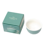 Teal ceramic bowl and packaging with 'Camellia Sinensis' branding on a white background