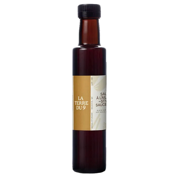 Bottle of La Terre du 9 sauce with a black cap on a white background